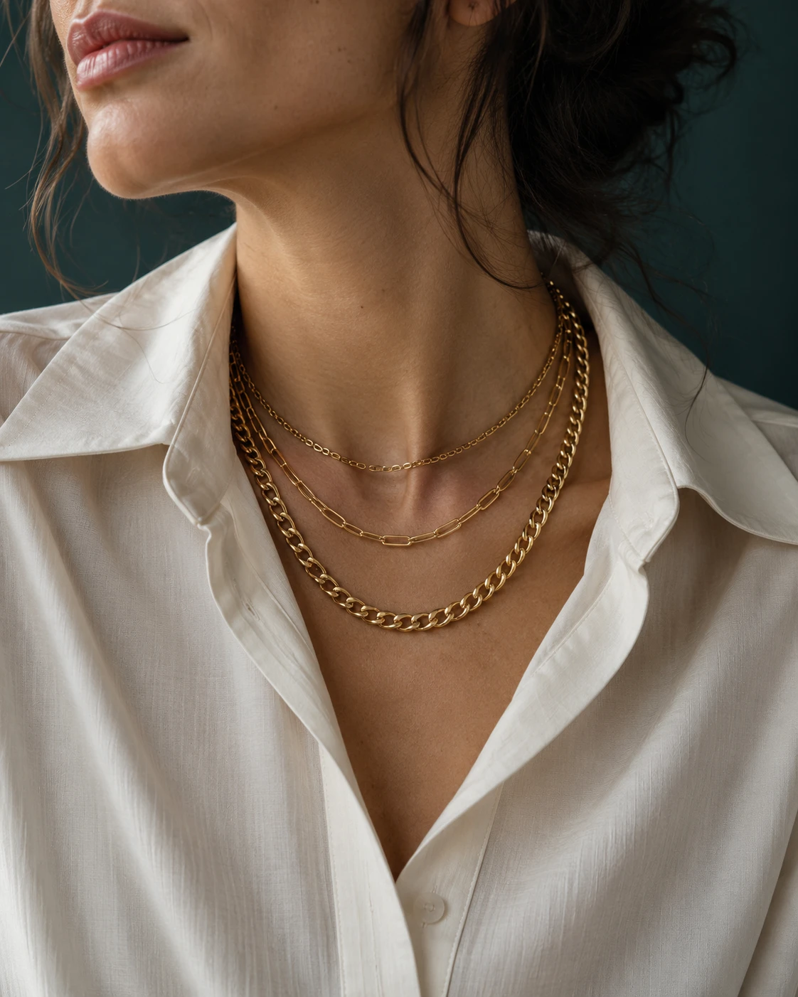 Layered gold chains styled with an ivory shirt